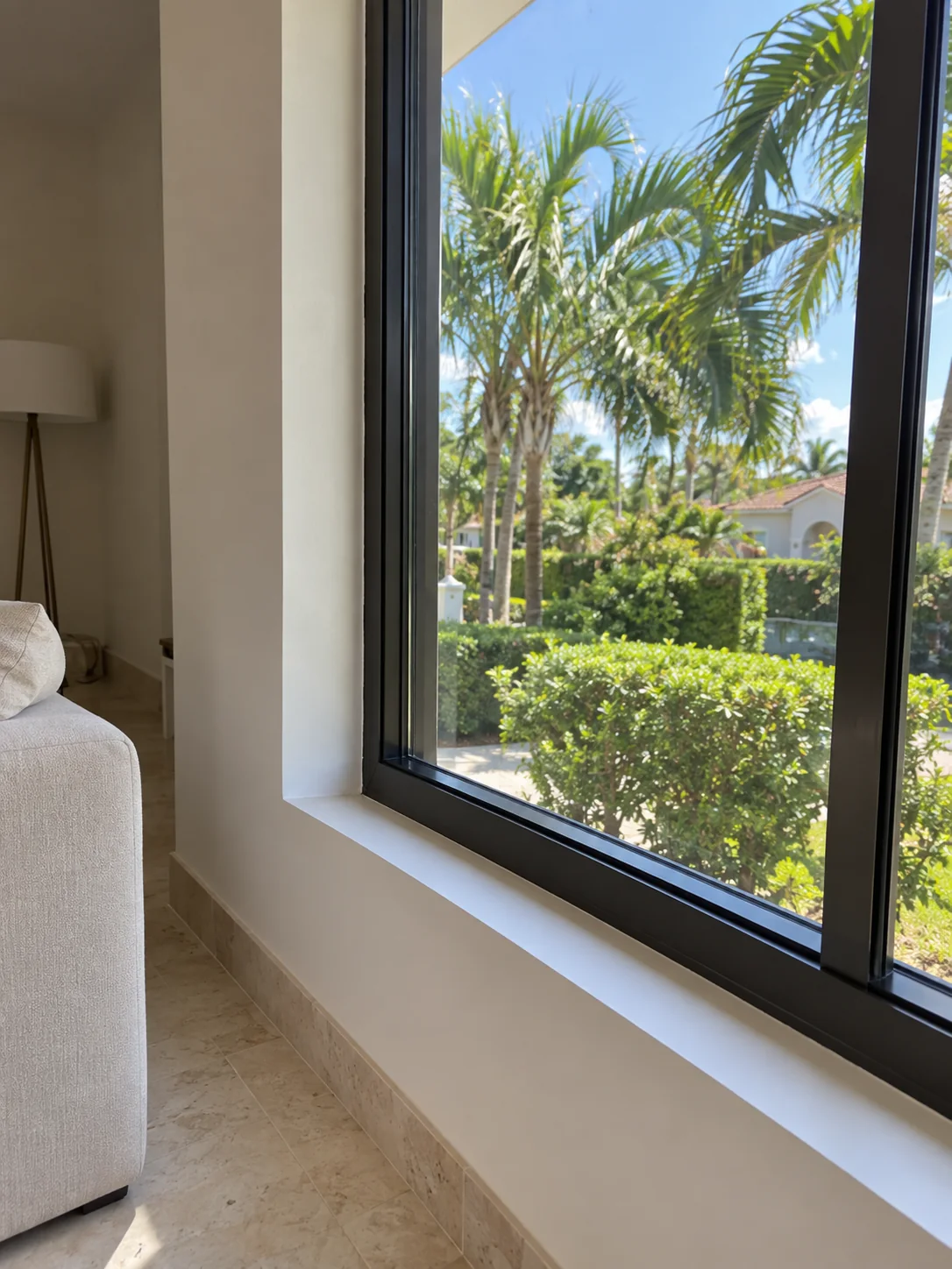Impact window with laminated glass and a dark aluminum frame in a South Florida living room
